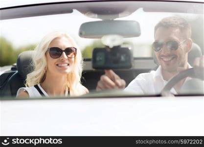 road trip, leisure, travel, technology and people concept - happy man and woman driving car and using gps navigation system