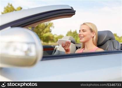 road trip, technology and communication concept - happy young woman calling on smartphone or using voice command recorder at convertible car. woman recording voice on smartphone at car