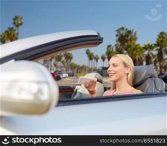 road trip, technology and communication concept - happy young woman calling on smartphone or using voice command recorder at convertible car over venice beach background in california. woman recording voice on smartphone at car. woman recording voice on smartphone at car