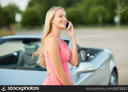 road trip, technology and communication concept - happy young woman calling on smartphone at convertible car. woman calling on smartphone at convertible car