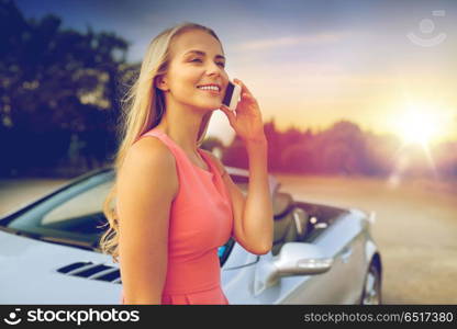 road trip, technology and communication concept - happy young woman calling on smartphone at convertible car. woman calling on smartphone at convertible car. woman calling on smartphone at convertible car