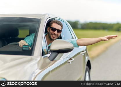 road trip, transport, travel and people concept - happy smiling man in sunglasses driving car and waving hand