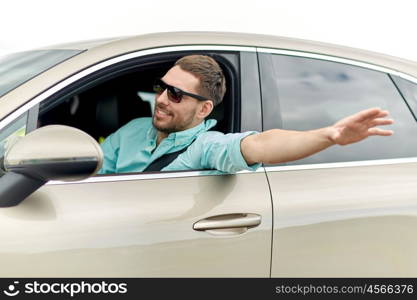 road trip, transport, travel and people concept - happy smiling man in sunglasses driving car and waving hand