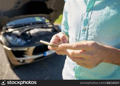 road trip, transport, travel, technology and people concept - close up of man with smartphone and broken car