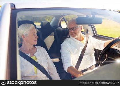 road trip, travel and old people concept - happy senior couple driving in car. happy senior couple driving in car