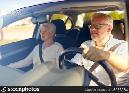 road trip, travel and old people concept - happy senior couple driving in car. happy senior couple driving in car