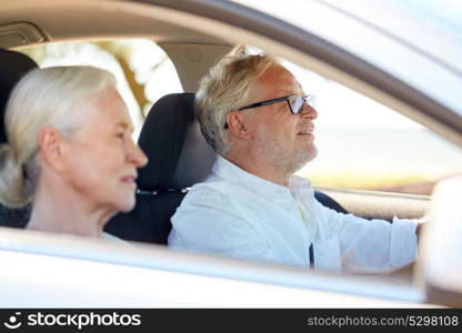 road trip, travel and old people concept - happy senior couple driving in car. happy senior couple driving in car