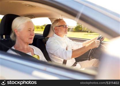 road trip, travel and old people concept - happy senior couple driving in car. happy senior couple driving in car