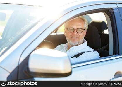 road trip, travel and old people concept - happy senior man in glasses driving car with open window. happy senior man driving car with open window