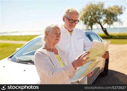 road trip, travel and old people concept - senior couple at car looking for location on map in summer. senior couple at car looking for location on map