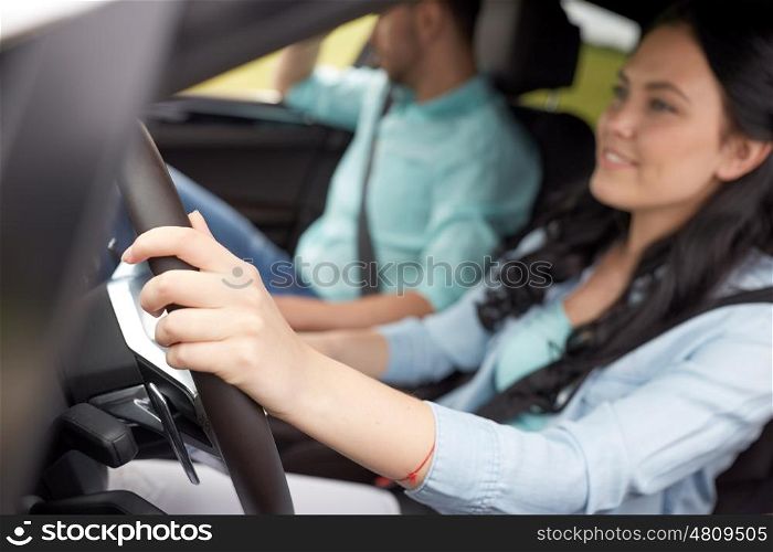 road trip, travel and people concept - happy man and woman driving in car