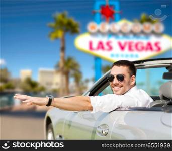 road trip, travel and people concept - happy man driving convertible car over welcome to fabulous las vegas sign background. happy man driving convertible car at las vegas. happy man driving convertible car at las vegas