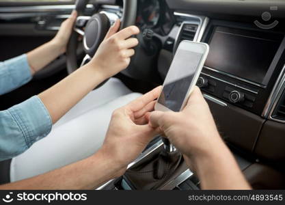 road trip, travel, destination technology and people concept - happy man and woman with navigator on smartphone driving in car