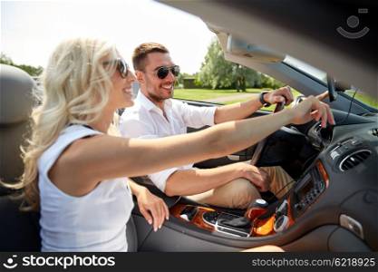 road trip, travel, summer vacation, technology and people concept - happy man and woman driving car and using gps navigator in cabriolet car