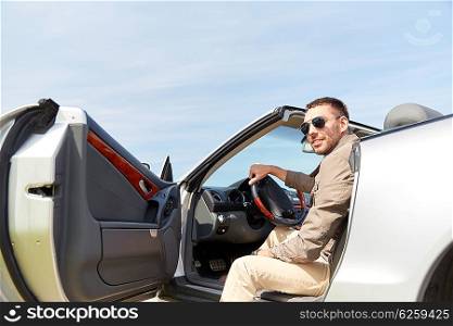 road trip, travel, transport, leisure and people concept - happy man opening door of cabriolet car outdoors