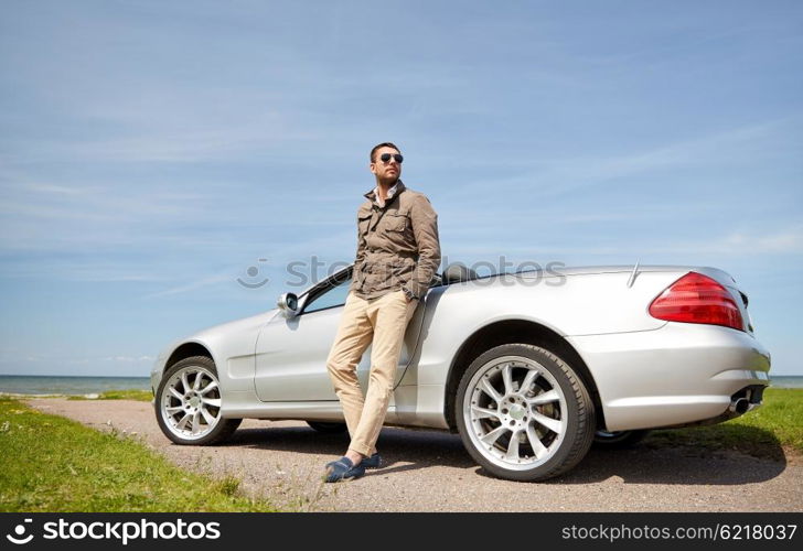 road trip, travel, transport, leisure and people concept - man near cabriolet car outdoors