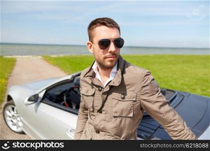 road trip, travel, transport, leisure and people concept - man near cabriolet car outdoors