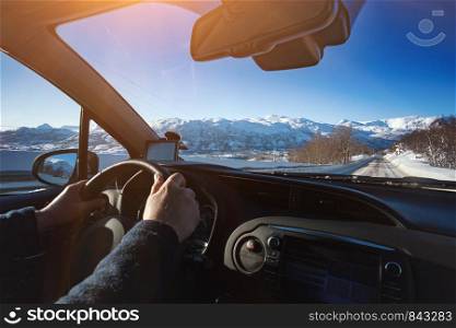 roadtrip - man hands on the wheel and norwegian mountains. Lofoten Islands. Norway.