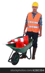 Roadworker with cones in a wheelbarrow