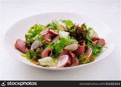 Roast beef salad with green mix on plate