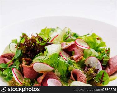 Roast beef salad with green mix on plate