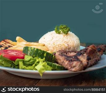 Roast chicken close-up with tomato salad and french fries, Roast chicken traditional food served on wooden table, plate with roasted chicken and rice served on wooden background