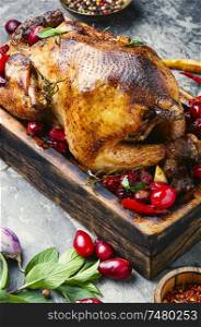 Roast chicken on cutting board with dogwood.Baked chicken in berry sauce. Baked chicken in berry sauce