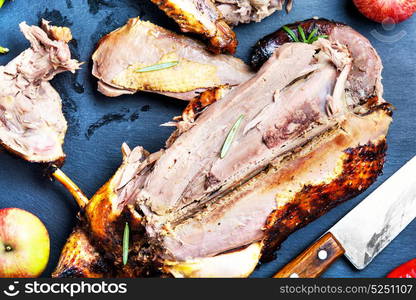 Roast duck with apples. Cutting roast duck and apples on blue slate board