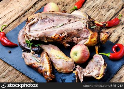Roast duck with apples. Cutting roast duck and apples on blue slate board