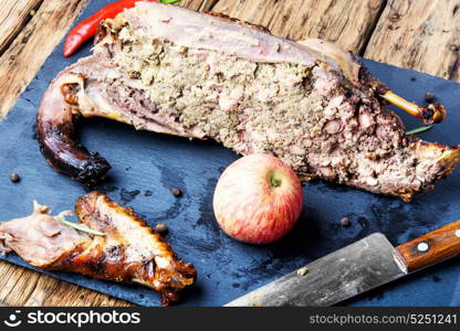 Roast duck with apples. Cutting roast duck and apples on blue slate board