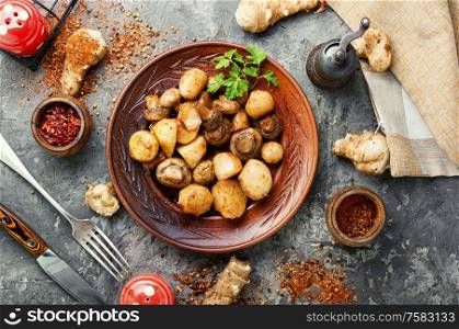 Roast Jerusalem artichoke with champignon mushrooms.Roast with potatoes and mushrooms.Vegetarian food.. Baked Jerusalem artichoke