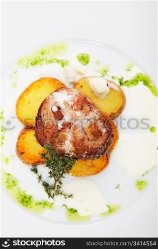 roast meat with potatoes on white plate