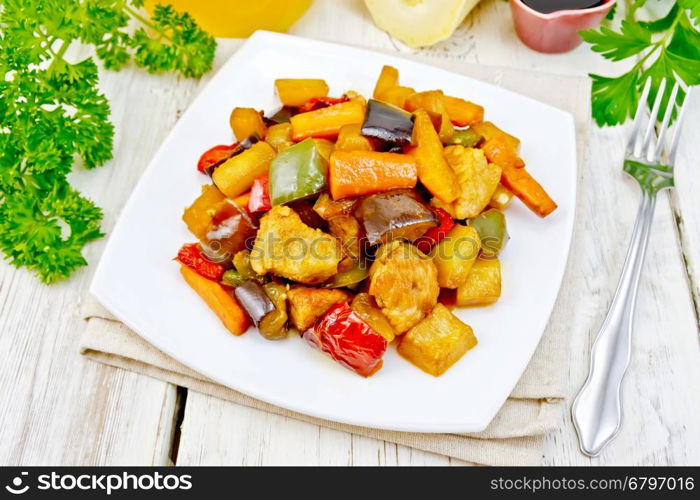 Roast meat, zucchini, eggplant, carrot and sweet pepper with honey, soy sauce and red wine in a plate on a napkin on the background light wooden boards