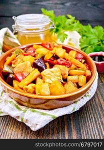 Roast of meat, zucchini, eggplant, carrot and sweet pepper with honey, soy sauce and red wine in a frying pan on a napkin against the background of wooden boards