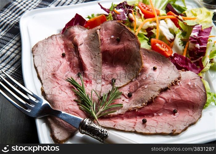 roastbeef on white dish with salad