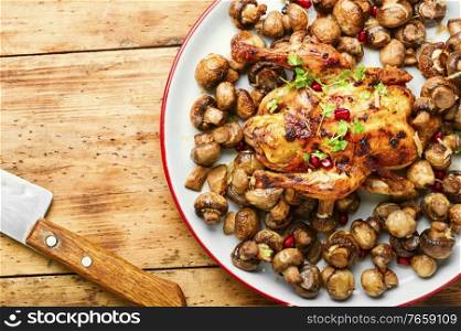 Roasted baked poult with mushrooms champignons on wooden table. Fried chick with mushrooms