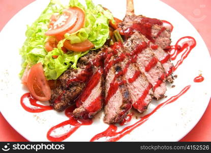 Roasted Beef meat at cranberries sauce with vegetables