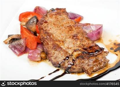 Roasted beef steak with vegetable closeup at plate