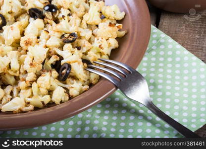 roasted cauliflower with olives on a wooden table