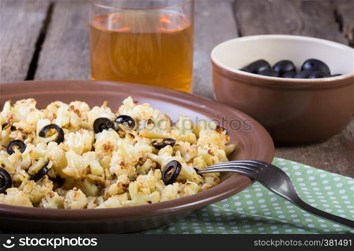 roasted cauliflower with olives on a wooden table