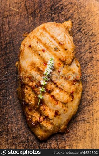 Roasted chicken breast on rustic wooden background, top view, close up