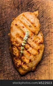 Roasted chicken breast on rustic wooden background, top view, close up