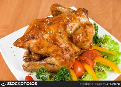 roasted chicken garnished with fresh tomatoes, green salad, pepper and greens