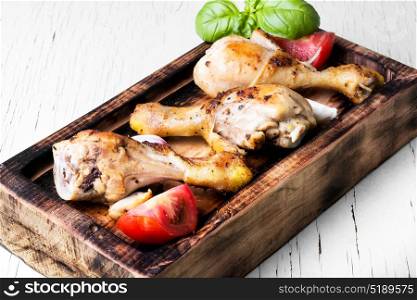 roasted chicken legs. chicken legs on kitchen board in light background