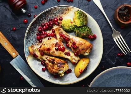 Roasted chicken legs, chicken meat with broccoli and cranberries. Baked chicken legs with broccoli.