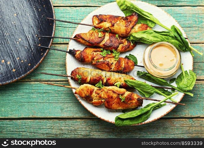 Roasted chicken meat. Chicken breast on a skewer. Meat kebab or shashlik with peanut sauce.. Chicken breast skewers, chicken satay
