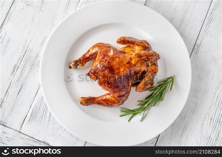 Roasted chicken on the white serving plate