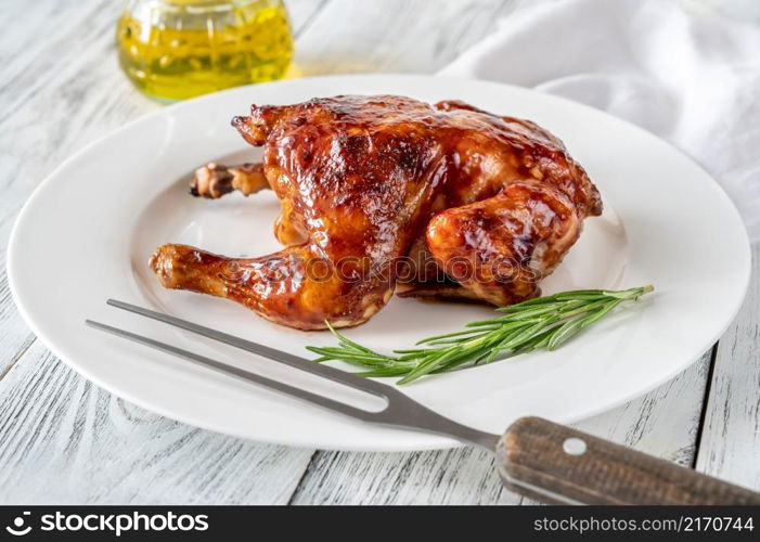 Roasted chicken on the white serving plate