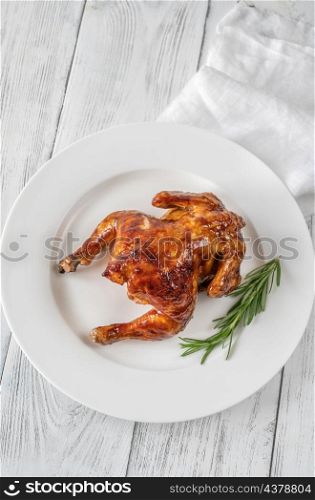 Roasted chicken on the white serving plate