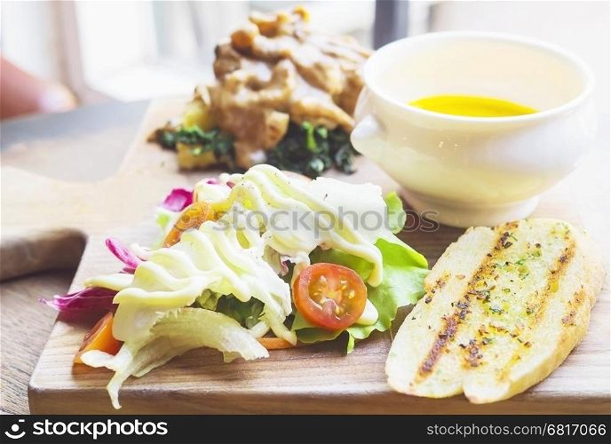 Roasted chicken served with salad and garlic bread